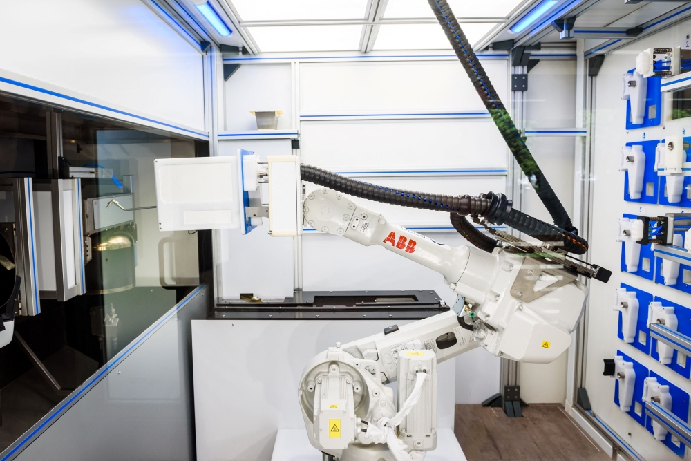 A photo taken on May 25, 2021 shows a robot seen behind a screen as it prepares food at the Roboeatz eatery in Riga.  A pasta order comes in and the robotic arm springs into action at the Roboeatz eatery in Riga. After five minutes of gyrations, a piping hot plate is ready. The Riga cafe is designed in such a way that customers can observe the robotic arm at work. A Roboeatz app allows customers to order and pay for their dish before picking it up at the cafe. 
 (Photo by Gints Ivuskans / AFP)

