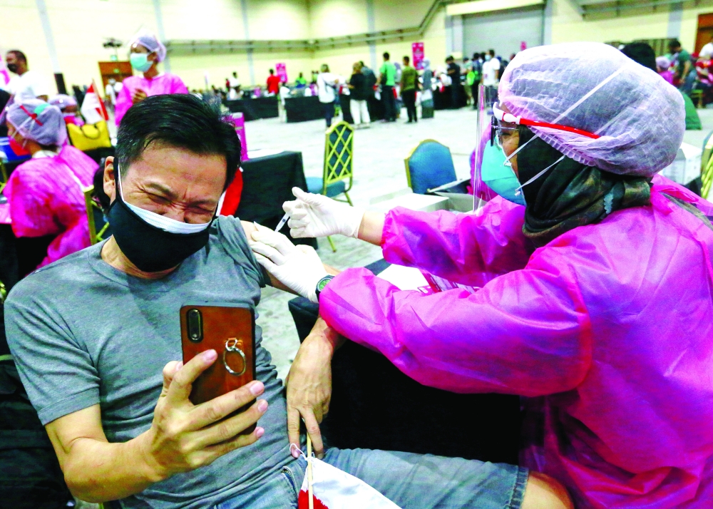 A man reacts as he receives a dose of a vaccine against the coronavirus disease during a mass vaccination programme in Jakarta. - Reuters

