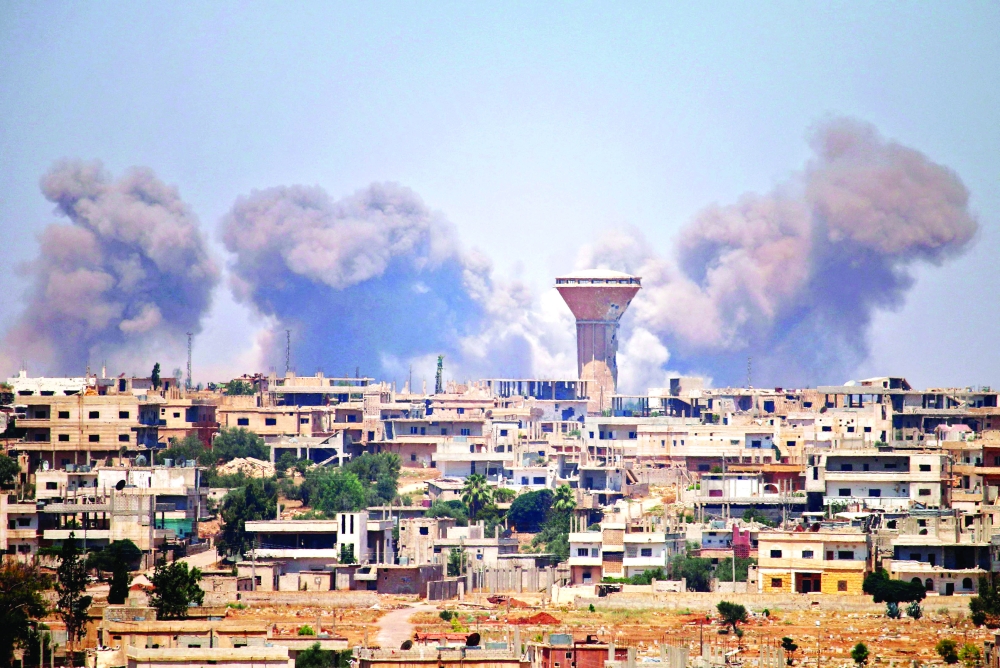 Ssmoke rises above rebel-held areas of the city of Daraa during reported airstrikes by Syrian regime forces. - AFP File Photo