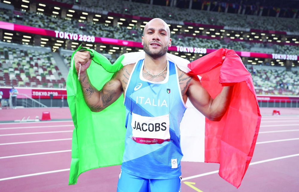 Italy's Lamont Marcell Jacobs celebrates after winning the men's 100m final during the Tokyo 2020 Olympic Games at the Olympic Stadium in Tokyo on August 1, 2021. (Photo by Christian Petersen / POOL / AFP)


