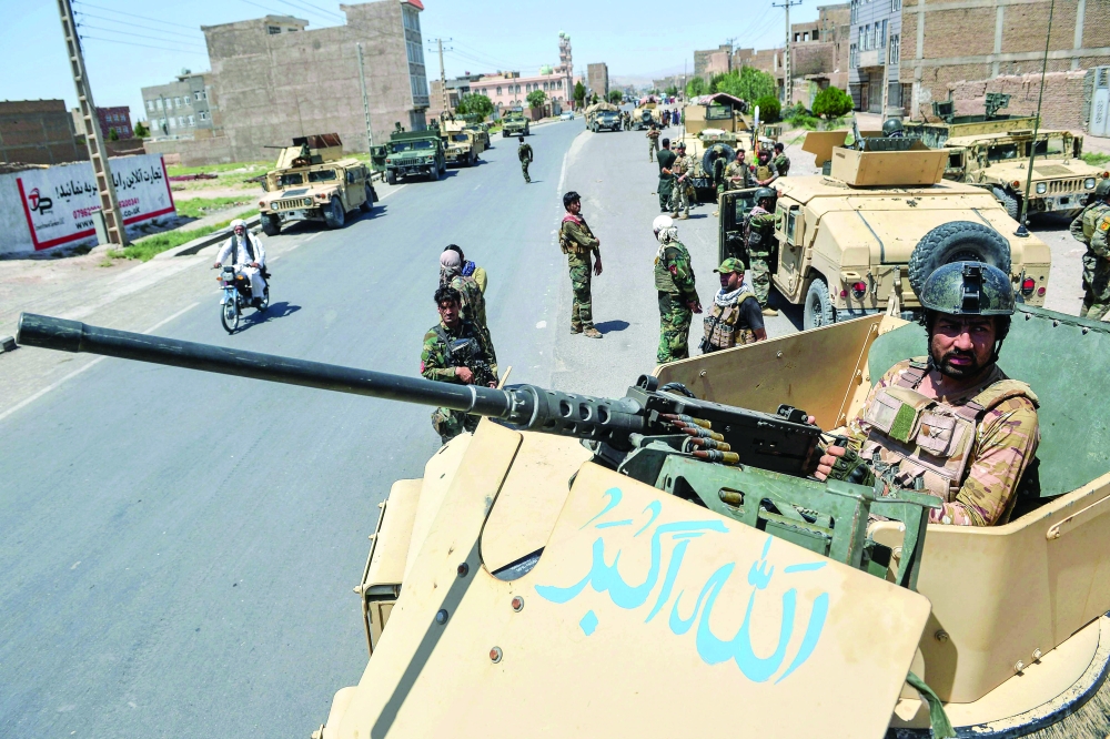 An Afghan National Army commando stands guard along the road in Enjil district of Herat province. - AFP