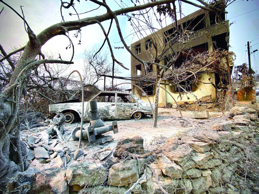 The town of Manavgat shows burnt car in front of a burnt house as a massive forest fire which engulfed a Mediterranean resort region on Turkey's southern coast. - AFP