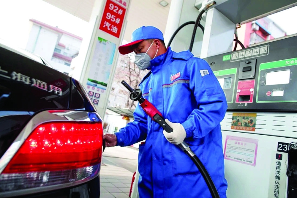 A pump attendant refuels a car at a gas station in Beijing, China. — Reuters