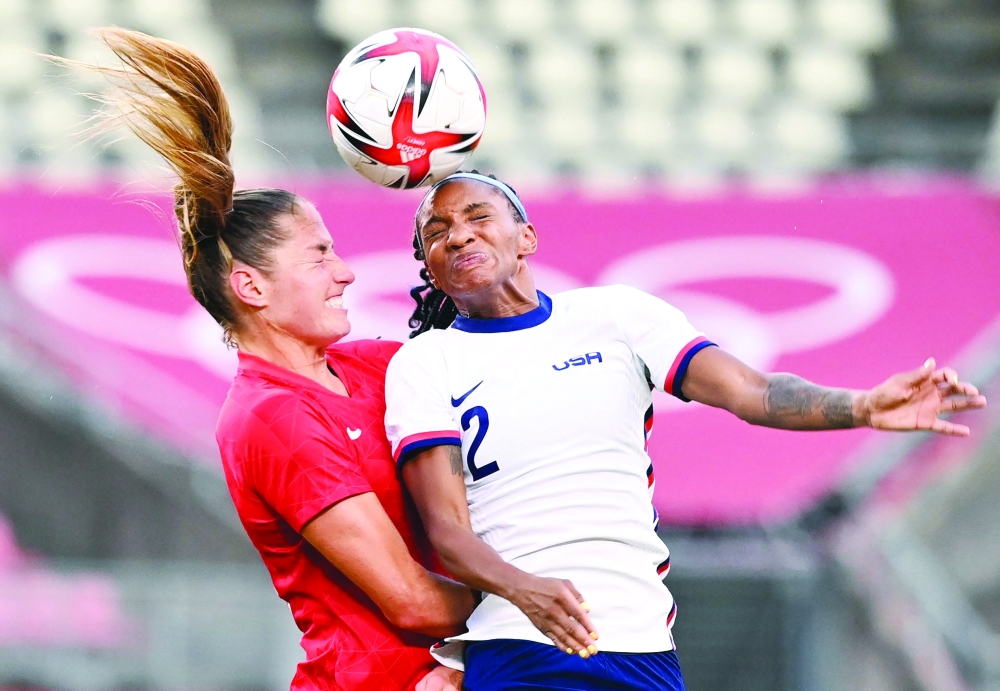 USA's defender Crystal Dunn (R) vies for the header with Canada's forward Janine Beckie during the Tokyo 2020 Olympic Games women's semi-final. -- AFP

