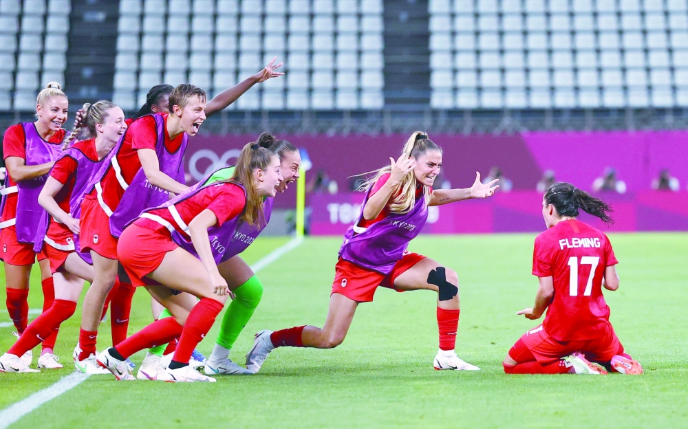 Jessie Fleming of Canada celebrates scoring their first goal from the penalty spot with teammates. -- Reuters