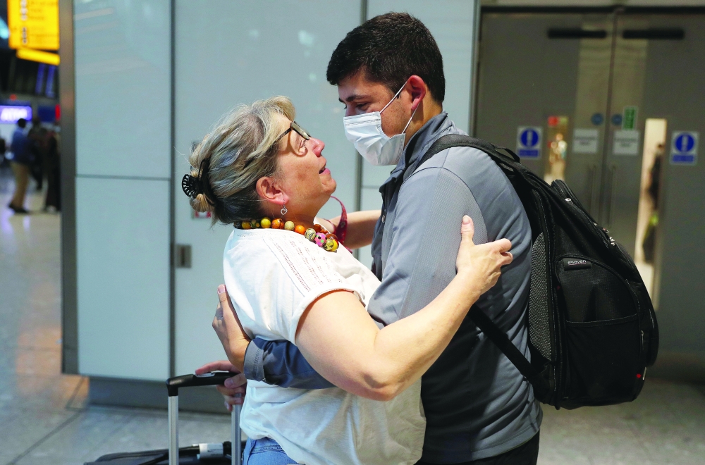 Karen Tyler embraces her son Jonathan who arrived from the US, at the International arrivals area of Terminal 5 in London's Heathrow Airport. - Reuters
