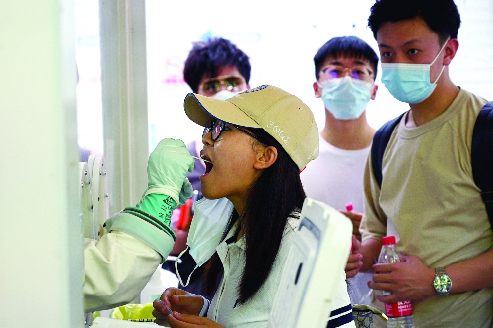 A swab sample is taken from a woman to be tested for the coronavirus at a hospital in Beijing. - AFP