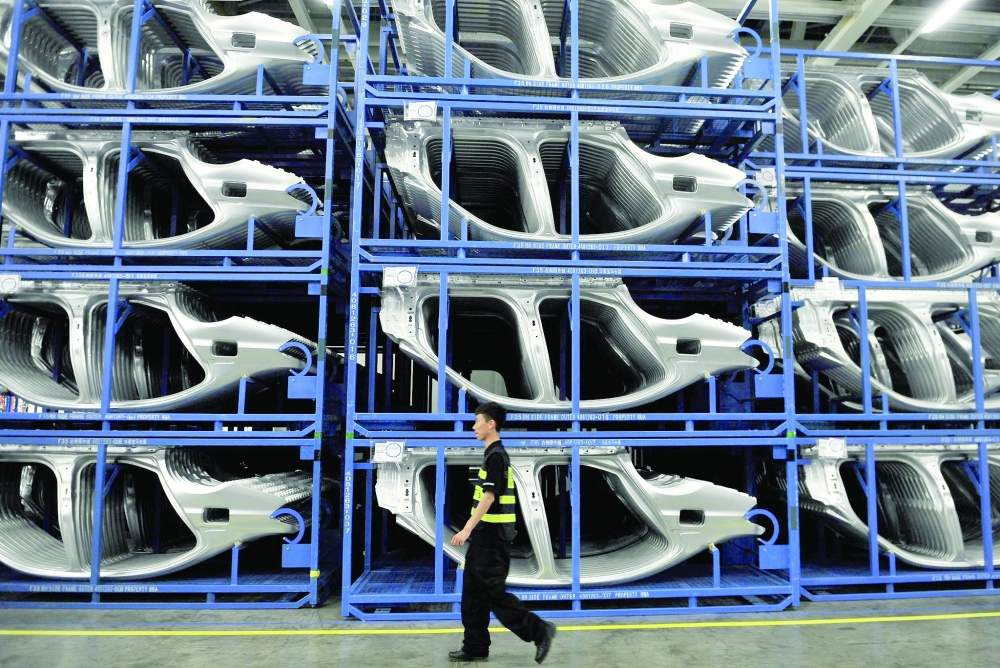 A man passes car frames at a BMW factory in Shenyang, China.— Reuters