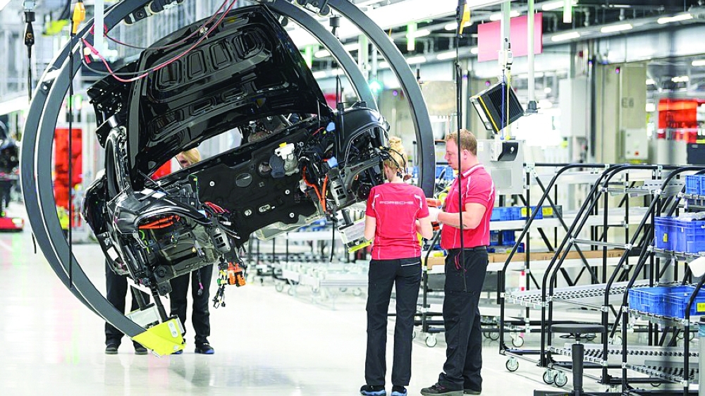 Employees assemble a car at Porsche AG plant in Stuttgart, southern Germany. — AFP