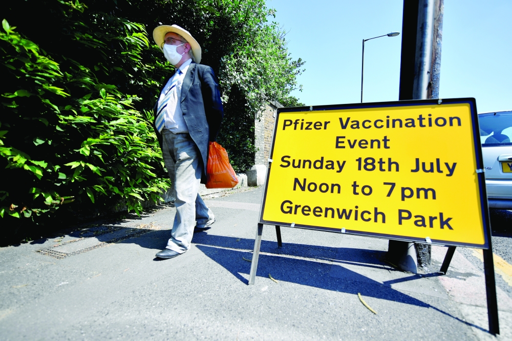FILE PHOTO: A person walks past a sign informing about a vaccination centre in Greenwich park, amid the coronavirus disease (COVID-19) outbreak, in London, Britain, July 18, 2021. REUTERS/Beresford Hodge/File Photo