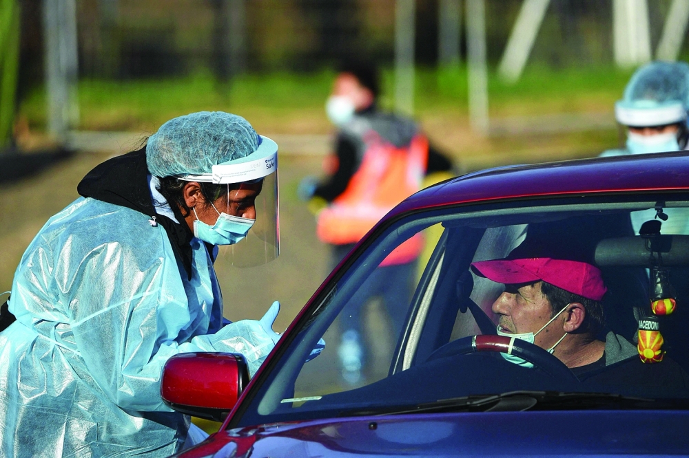 A health worker takes a swab sample from a resident at a Covid-19 drive-through testing site in western Sydney on Wednesday. - AFP