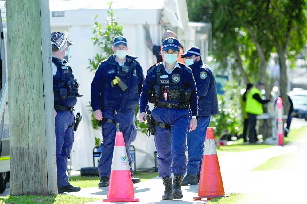 Police walk outside a residential building in the southwestern Sydney suburb of Campbelltown after residents were placed in isolation due to reports of Covid infections within the building. - AFP
