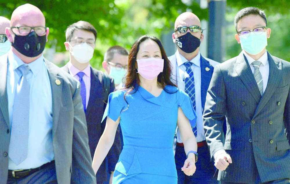 Huawei CFO Meng Wanzhou arrives at British Columbia Supreme Court with her security detail of her extradition hearing in Vancouver, Canada. - AFP

