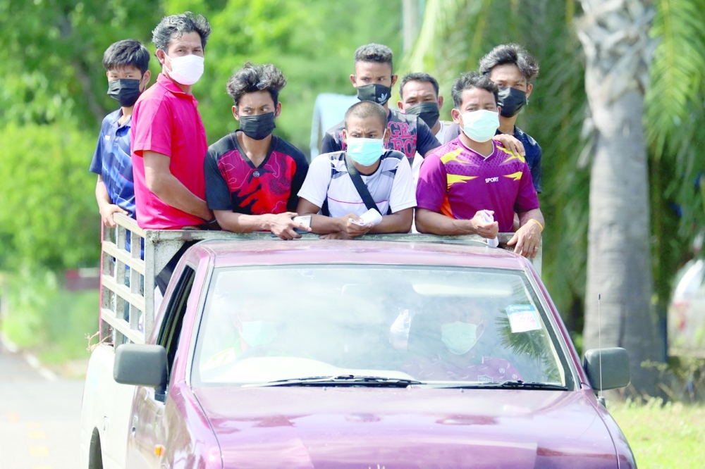 People wearing face masks ride on the flatbed of a truck as they arrive at the Prince of Songkla University Pattani campus to receive the AstraZeneca vaccine in Pattani. - AFP 