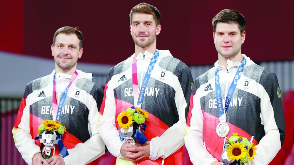 Silver medallists Timo Boll of Germany, Patrick Franziska of Germany and Dimitrij Ovtcharov of Germany react on the podium. -- Reuters