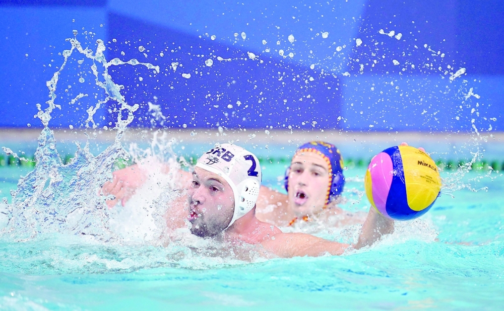 Serbia's Dusan Mandic swims with the ball during the Tokyo 2020 Olympic Games men's water polo semi-final match between Serbia and Spain. -- AFP
