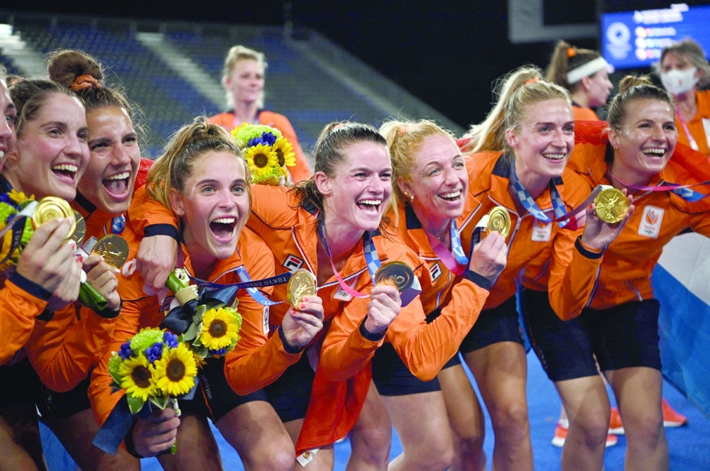 Netherlands' gold medallists celebrate after the medal ceremony of the Tokyo 2020 Olympic Games women's field hockey competition. -- AFP