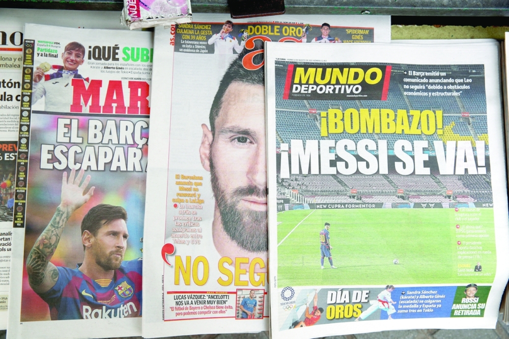 Newspapers are seen displaying front page images of Barcelona's Lionel Messi at a newspaper selling stall outside the Camp Nou. -- Reuters