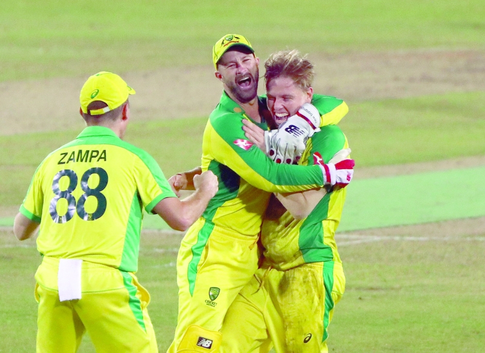 Australia's Nathan Ellis celebrates with his teammates after taking the wicket of Bangladesh's Mahedi Hasan to complete his hat-trick. -- Reuters
