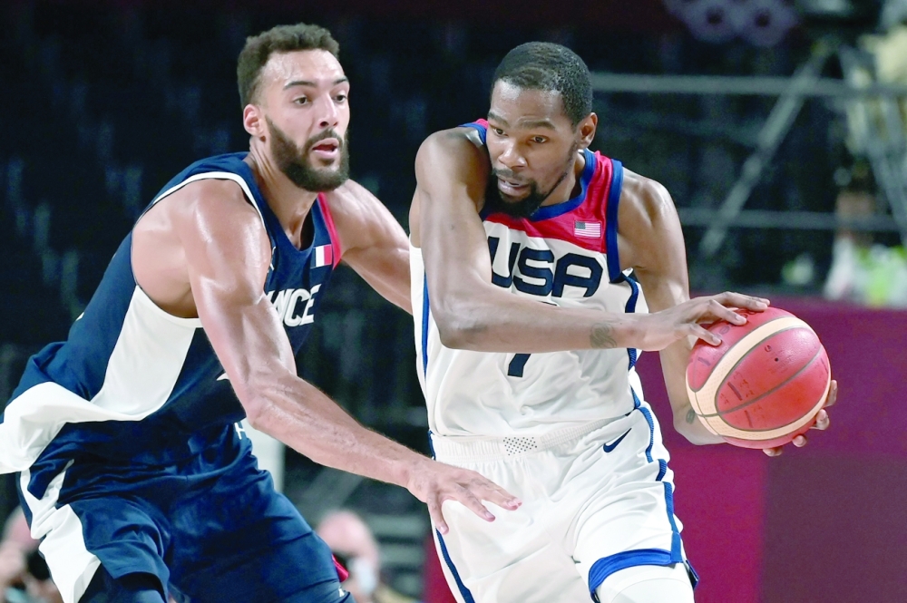 USA's Kevin Wayne Durant (R) dribbles the ball past France's Rudy Gobert in the men's final basketball match. -- AFP