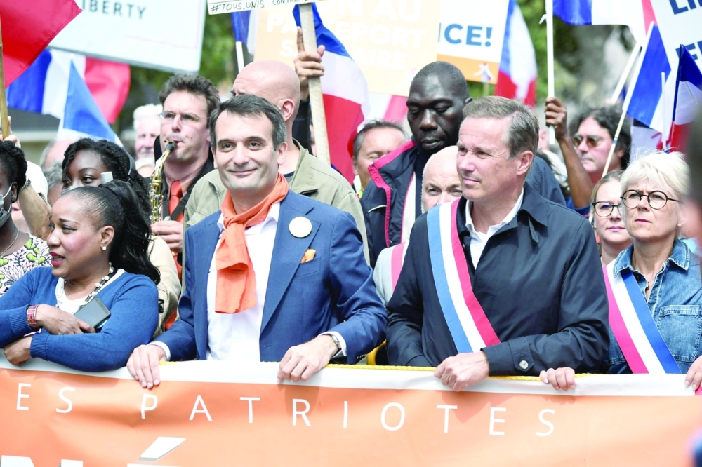 French nationalist party The Patriots party leader Florian Philippot (C,L) and far-right party Head of Debout la France's head Nicolas Dupont-Aignan march during a demonstration in Paris. - AFP