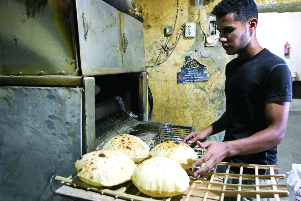 A baker collects loaves at a bakery in Cairo. - Reuters