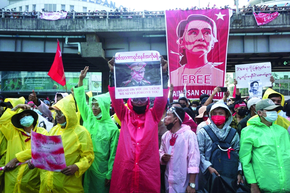 Protesters wear wet weather gear to protect against police water cannon as they take part in a demonstration against the military coup in Yangon. AFP file photo