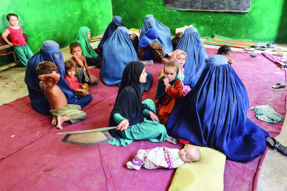 Internally displaced families sit inside a school after they left their house following fighting between Afghan security forces and Taliban, in Ghaziabad District in the northern part of Kunar province on Saturday. -- AFP