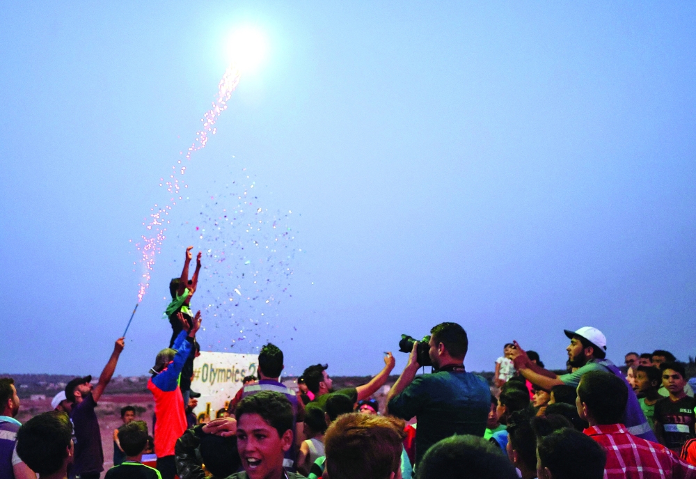 Displaced Syrian boys stand on the podium after winning medals in the so-called "Camp Olympics 2020" in the town of Fuaa. -- AFP