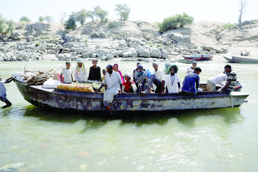 Ethiopians fleeing from the Tigray region arrive by boat to Sudan after crossing a river between the two countries, near the Hamdayet refugee transit camp. Reuters file photo