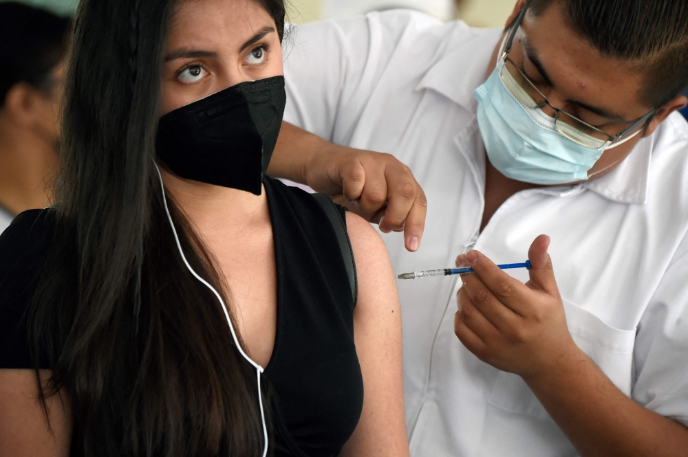 A young woman receives her first dose of the Sputnik-V vaccine against COVID-19 in Mexico City. 