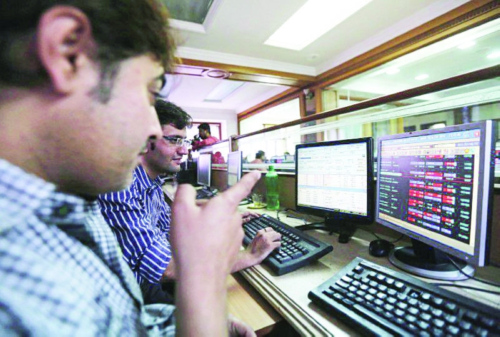 Brokers trade at their computer terminals at a stock brokerage firm in Mumbai, India. — Reuters