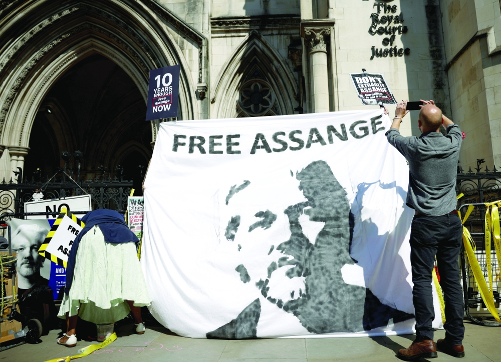Supporters of Wikileaks founder Julian Assange display a banner outside the Royal Courts of Justice in London on Wednesday. -- Reuters