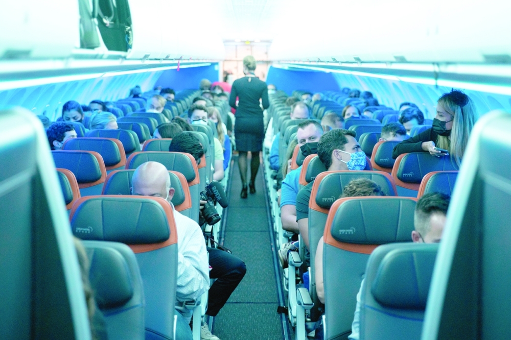 Passengers wearing protective masks are seen aboard before a flight to London at JFK International Airport in the Queens borough of New York City. -- Reuters