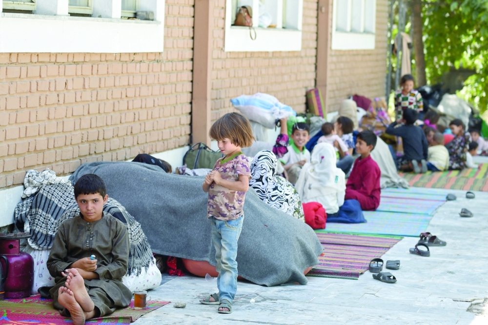 Internally displaced Afghan families, who fled from the northern province due to battle between Taliban and Afghan security forces, sit in the courtyard of the Wazir Akbar Khan mosque in Kabul on Saturday. -- AFP