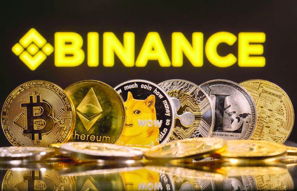 Representations of Bitcoin, Ethereum, DogeCoin, Ripple, and Litecoin are seen in front of a displayed Binance logo in this illustration photo. — Reuters
