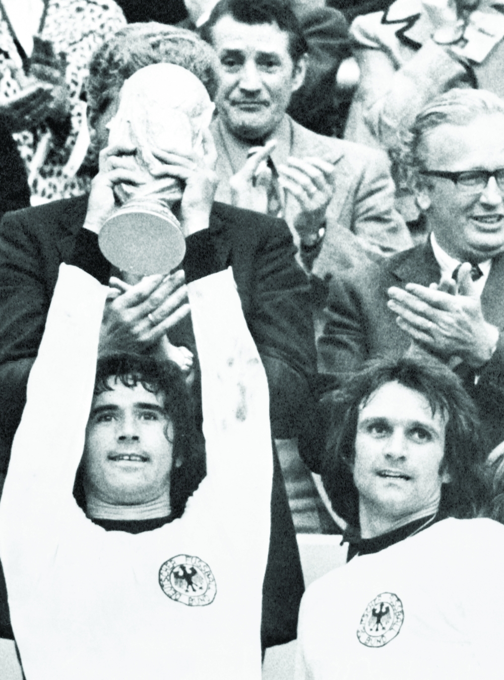 West Germany's Gerd Müller (L) raises the World Cup trophy after victory in the 1974 World Cup final between West Germany and Holland at The Olympic Stadium in Munich. -- AFP