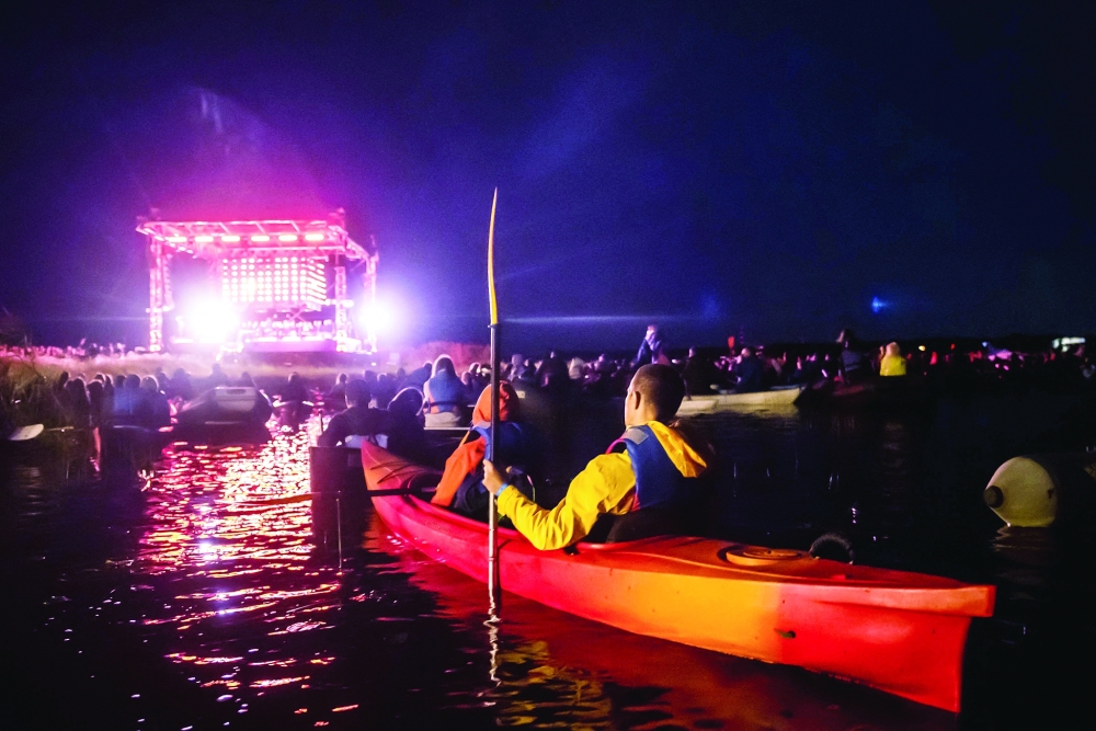 People in a boat listen to Latvian band Dagamba performing during a concert of the crossover music festival Laiva on Juglas Lake near Riga on Sunday. -- AFP

