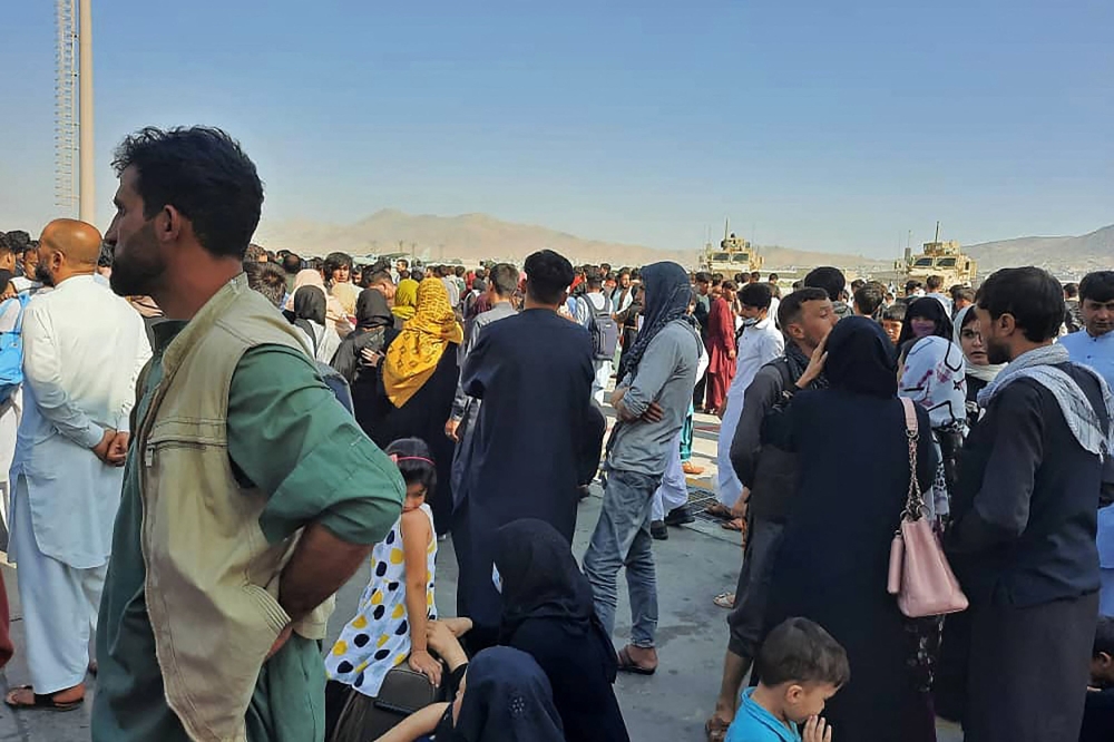 Afghans crowd at the tarmac of the Kabul airport on August 16, 2021, to flee the country as the Taliban were in control of Afghanistan 
