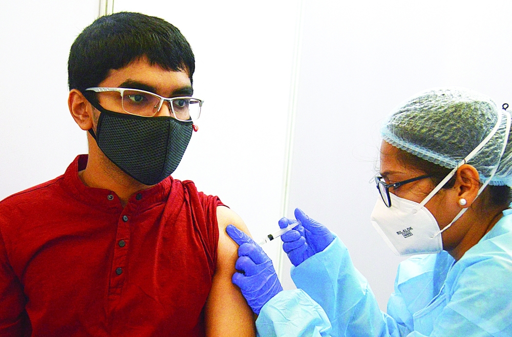 A health worker inoculates a man with a dose of the vaccine against the coronavirus in Mumbai on Tuesday. -- AFP
