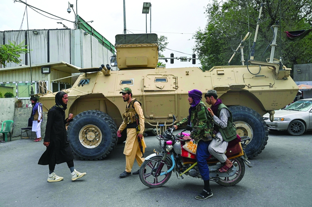 Taliban fighters patrol along a street in Kabul on Tuesday. -- AFP