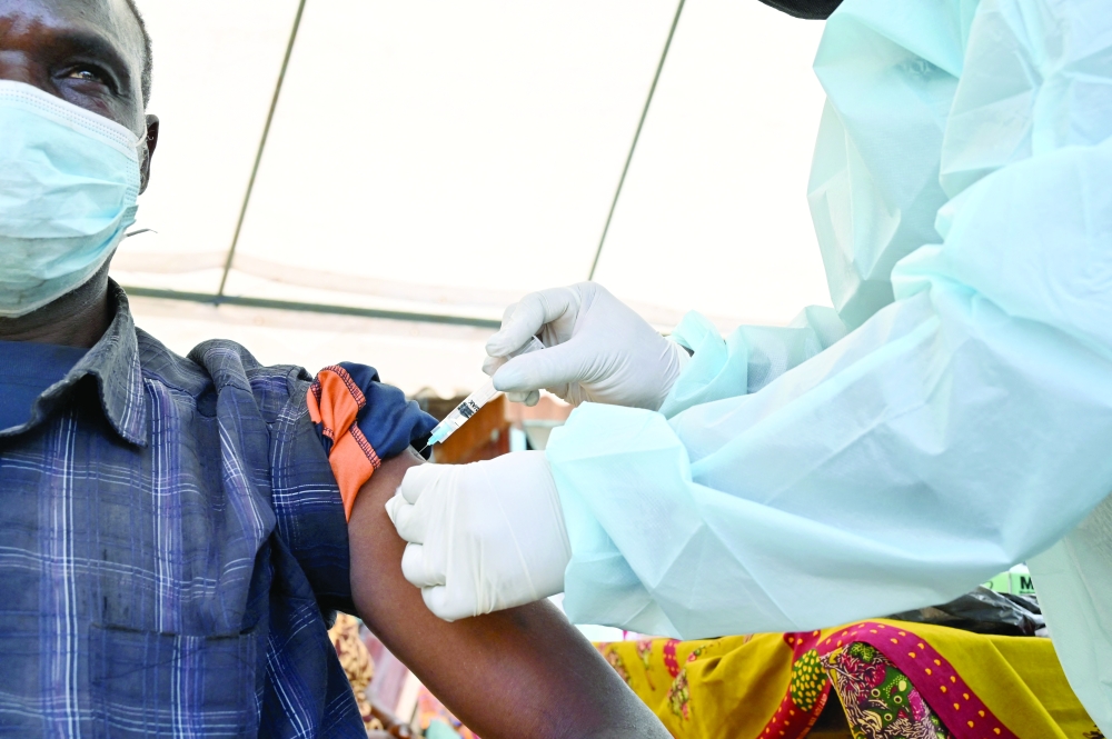 A health worker vaccinates a man in Abidjan, Nigeria on Wednesday. -- AFP