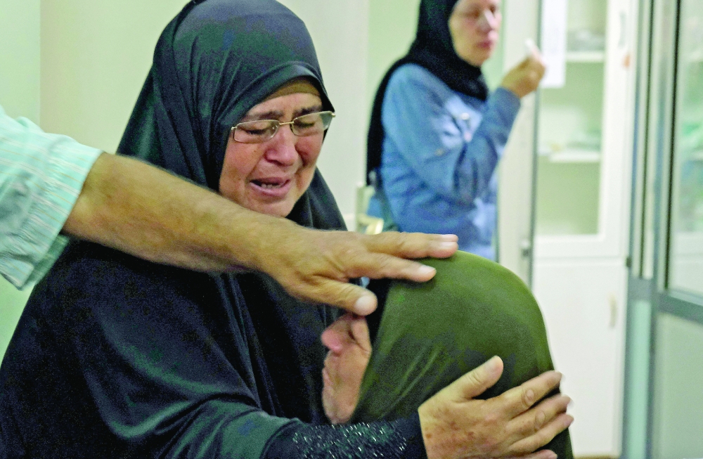 Relatives of one of the wounded in Akkar's fuel tank explosion mourn at the As Salam Hospital in Tripoli. -- AFP