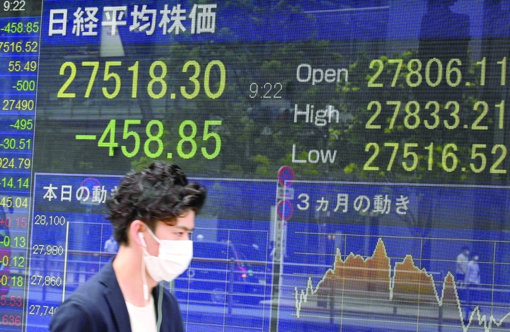 A man walks past an electronic quotation board displaying a share price of the Tokyo Stock Exchange in Tokyo. - AFP
