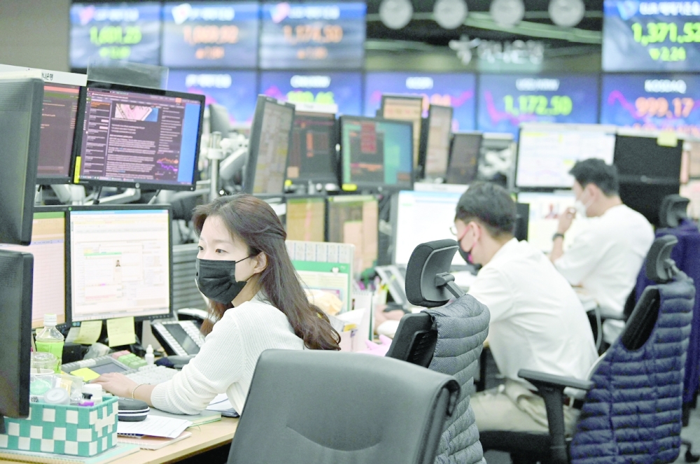 Currency dealers monitor exchange rates in a trading room at KEB Hana Bank in Seoul. - AFP