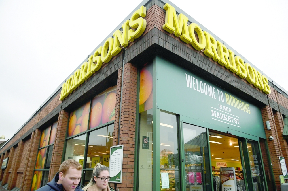 Shoppers walk past a branch of the food retailer Morrisons in west London. - Reuters File
