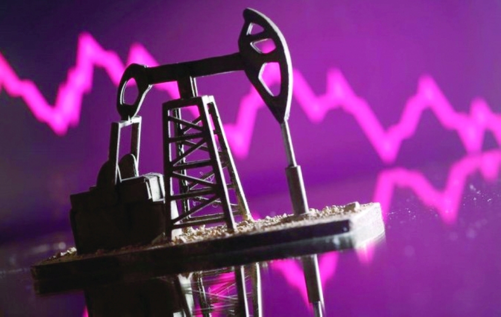 A 3D printed oil pump jack is seen in front of displayed stock graph in this illustration picture. — Reuters