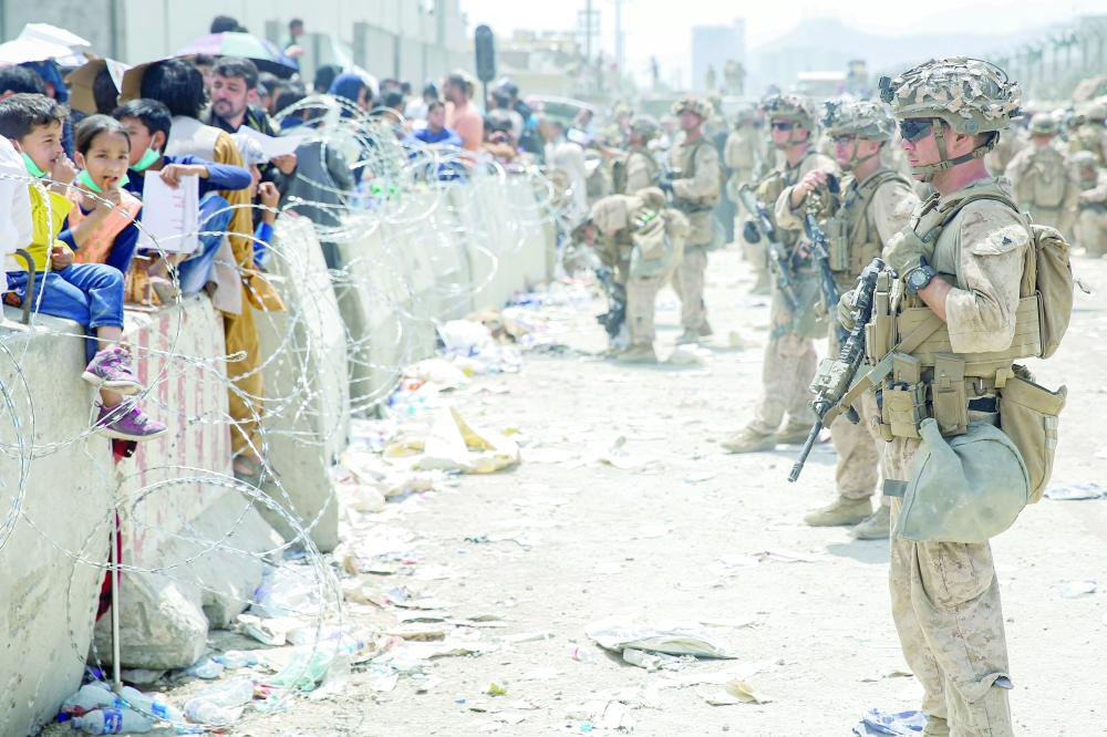 US Marines provide assistance during an evacuation at Hamid Karzai International Airport, in Kabul, on Friday. -- AFP
