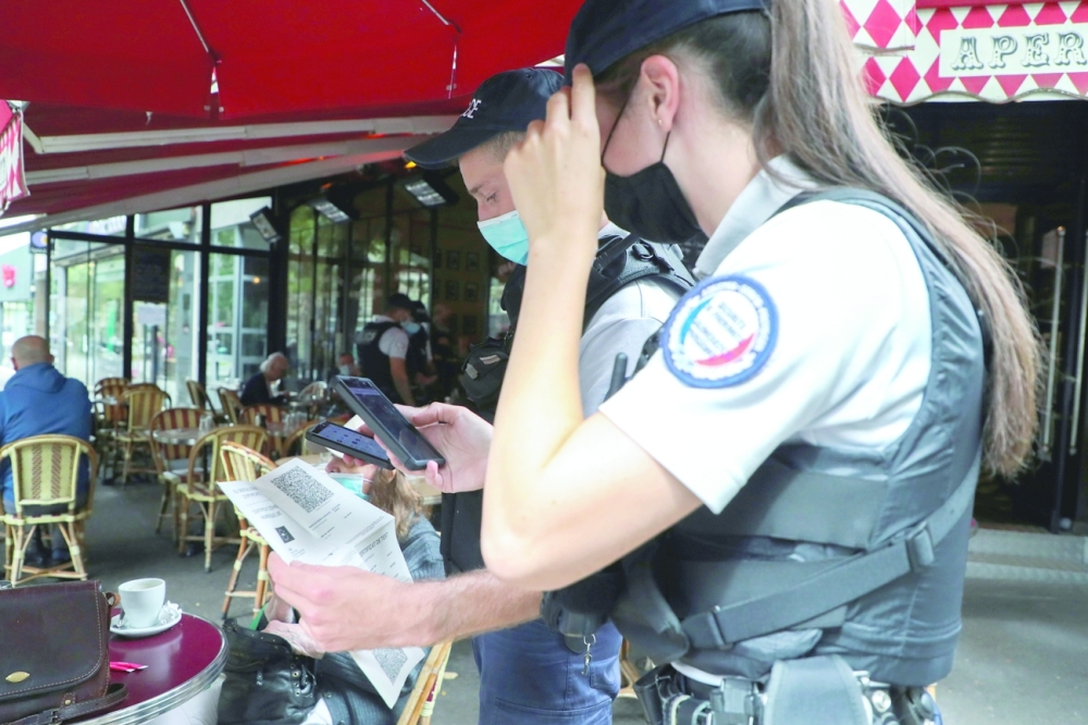 Police patrol restaurants to check health pass compliance in Paris. -- AFP