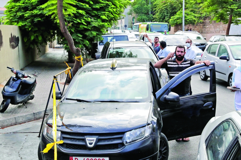 Lebanese wait in a queue outside a closed petrol station in Beirut's Hamra district. -- AFP 